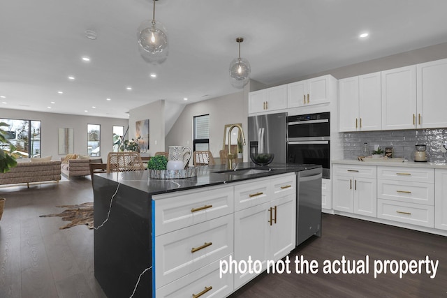 kitchen featuring appliances with stainless steel finishes, backsplash, a sink, and dark wood finished floors