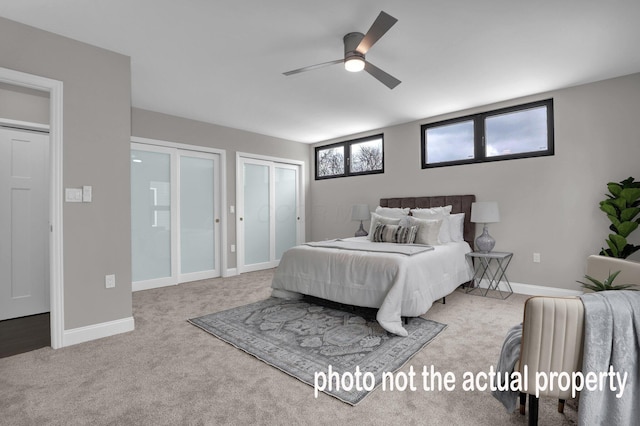 bedroom with carpet floors, two closets, a ceiling fan, and baseboards