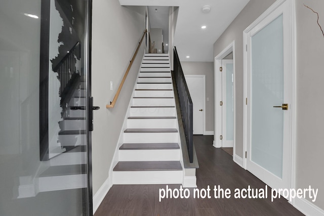 staircase featuring baseboards, wood finished floors, and recessed lighting