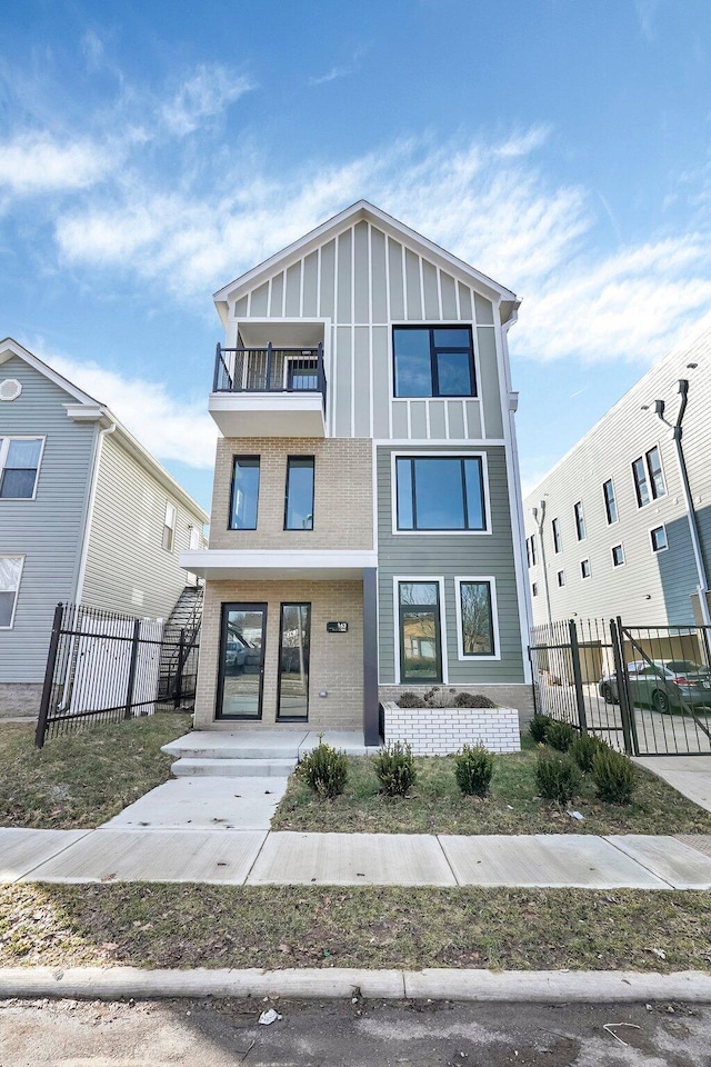 view of front facade featuring a balcony, fence, and board and batten siding