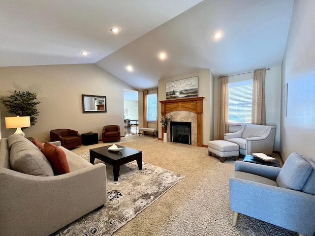 living room featuring a tiled fireplace, carpet floors, and lofted ceiling