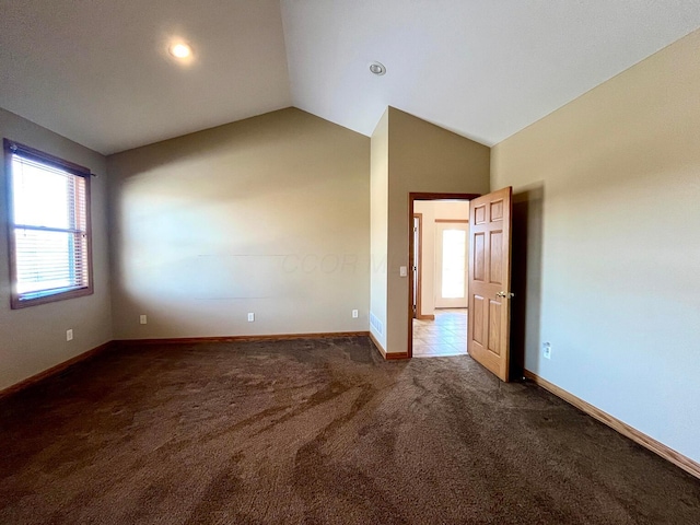 carpeted spare room featuring lofted ceiling