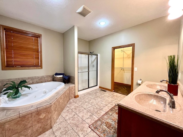 bathroom with tile patterned flooring, a textured ceiling, vanity, and separate shower and tub