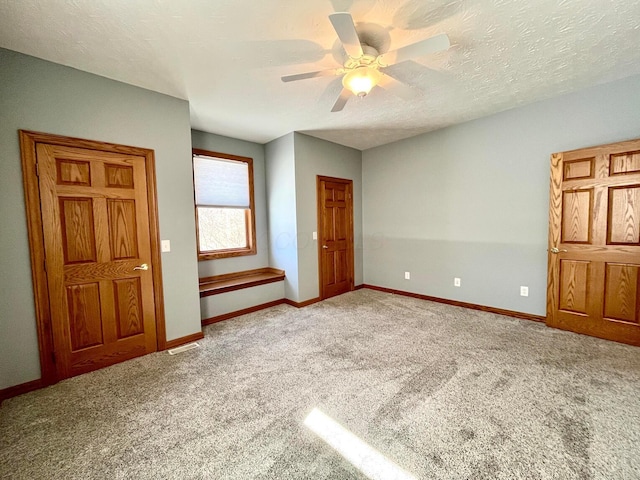 unfurnished bedroom featuring carpet, ceiling fan, and a textured ceiling