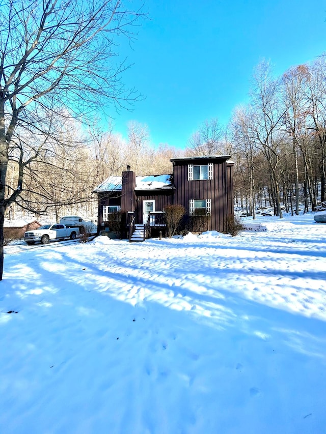 exterior space featuring board and batten siding and a chimney