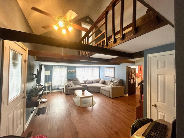 living area with a ceiling fan, beam ceiling, visible vents, and wood finished floors