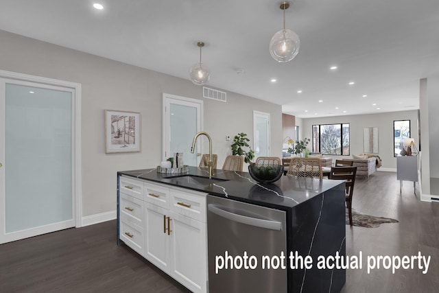 kitchen with sink, pendant lighting, dishwasher, white cabinetry, and an island with sink