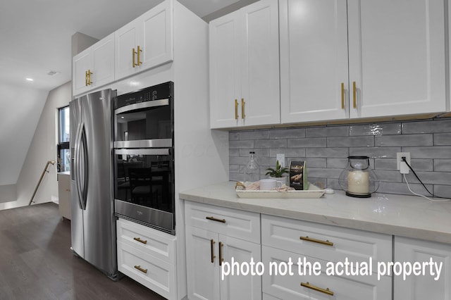 kitchen featuring white cabinetry, dark wood-type flooring, light stone counters, backsplash, and appliances with stainless steel finishes