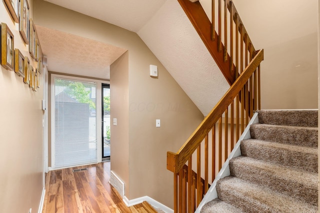 foyer featuring lofted ceiling and hardwood / wood-style flooring