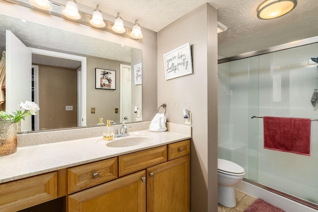 bathroom featuring vanity, tile patterned floors, toilet, a textured ceiling, and a shower with shower door