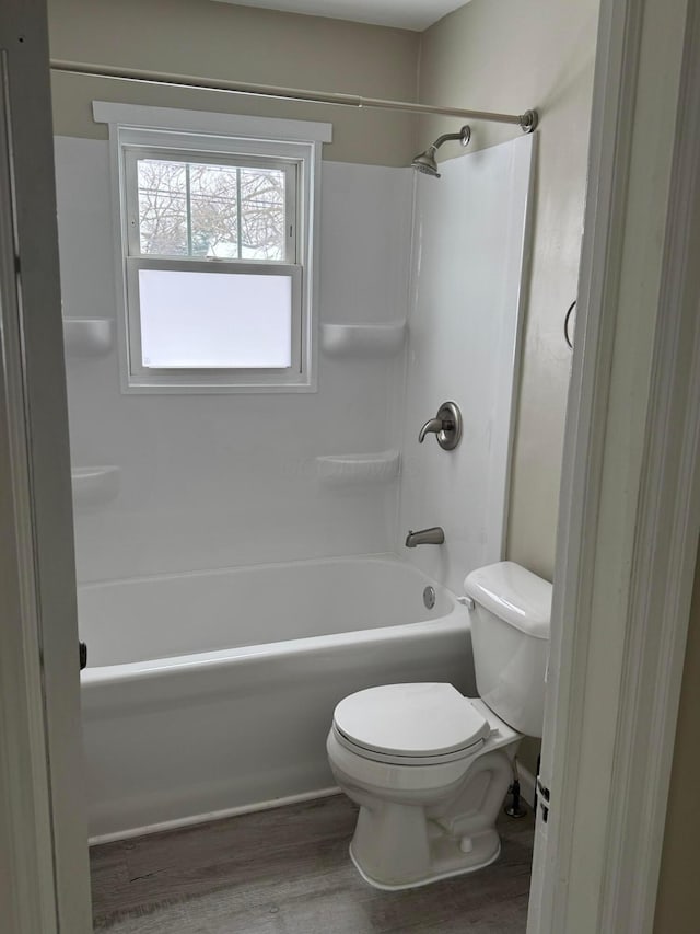 bathroom with toilet, shower / tub combination, and hardwood / wood-style floors