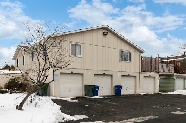 view of snow covered exterior featuring a garage