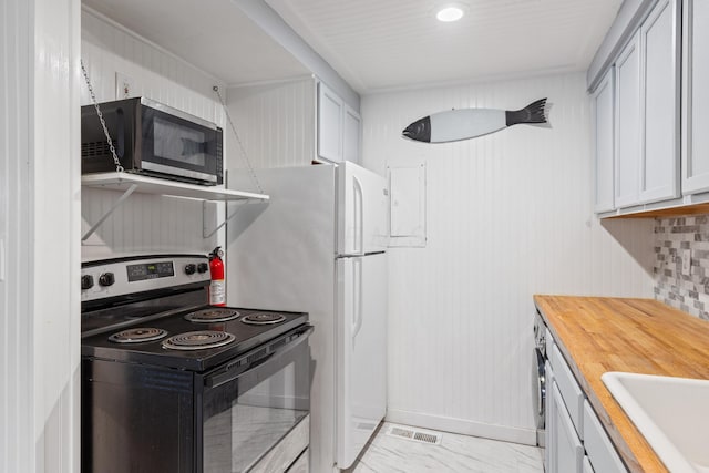 kitchen featuring white refrigerator, sink, wood counters, and black range with electric cooktop