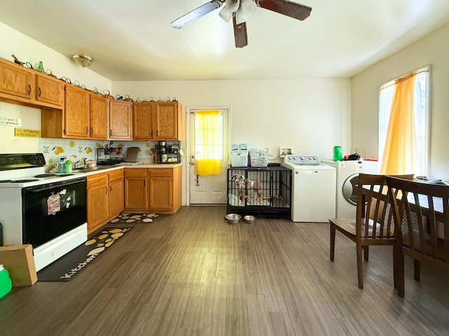 kitchen featuring tasteful backsplash, washing machine and clothes dryer, range with electric cooktop, dark wood-type flooring, and ceiling fan