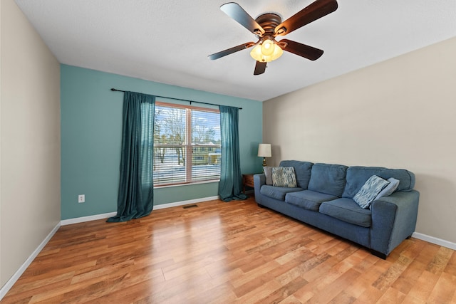 living room featuring light wood-type flooring and ceiling fan