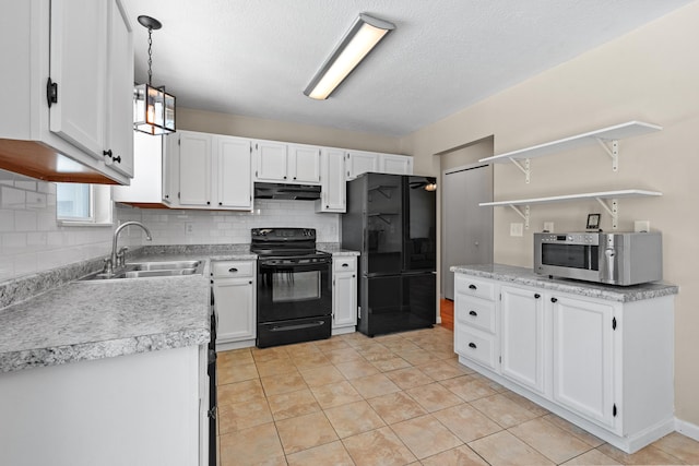 kitchen featuring black appliances, light tile patterned floors, pendant lighting, white cabinets, and sink