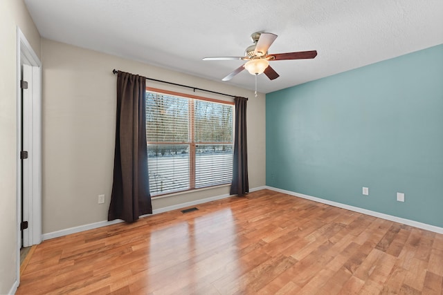 spare room featuring a textured ceiling, ceiling fan, and light hardwood / wood-style floors