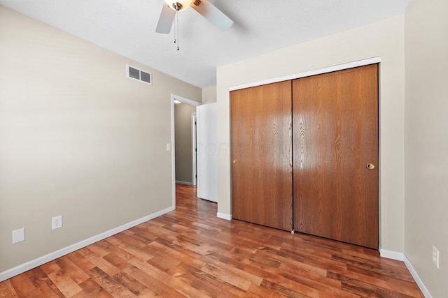 unfurnished bedroom with a closet, ceiling fan, and hardwood / wood-style flooring