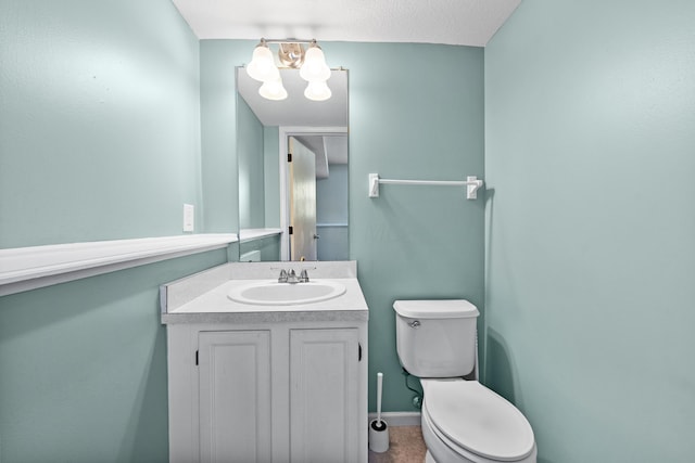 bathroom featuring an inviting chandelier, vanity, and toilet