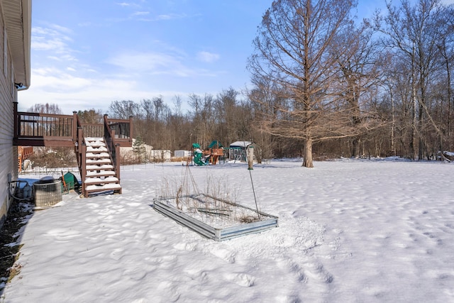 yard covered in snow featuring a playground