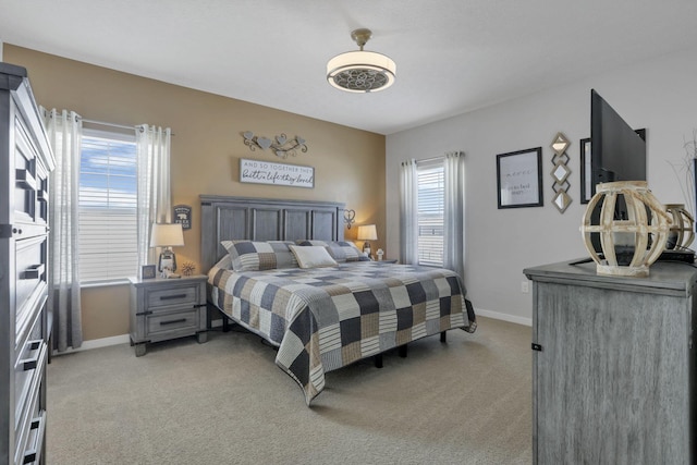 bedroom with multiple windows and light colored carpet