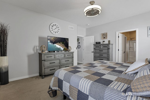 bedroom with ensuite bathroom and light carpet