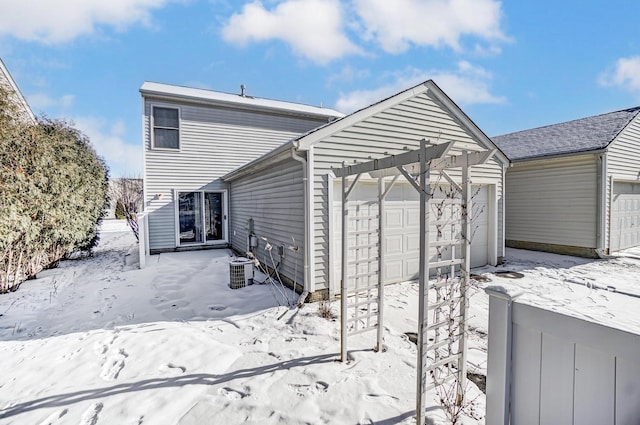 snow covered back of property with a garage