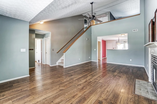 unfurnished living room with a tiled fireplace, hardwood / wood-style flooring, a textured ceiling, and ceiling fan