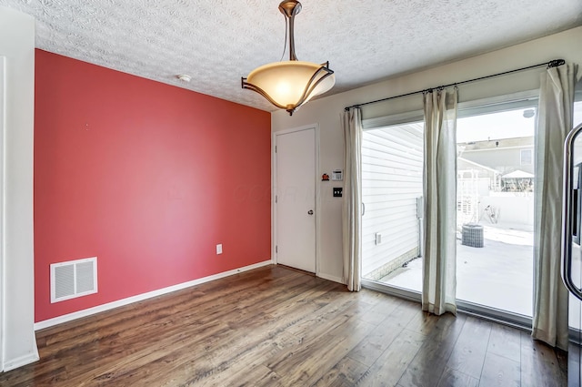 doorway to outside with dark hardwood / wood-style flooring and a textured ceiling