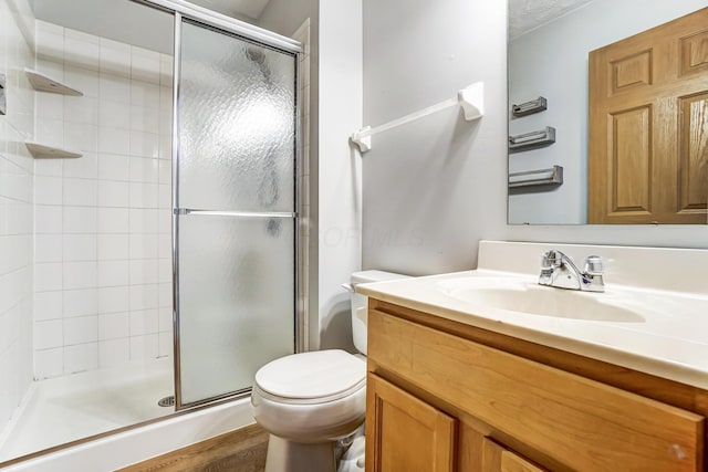 bathroom with walk in shower, vanity, and toilet