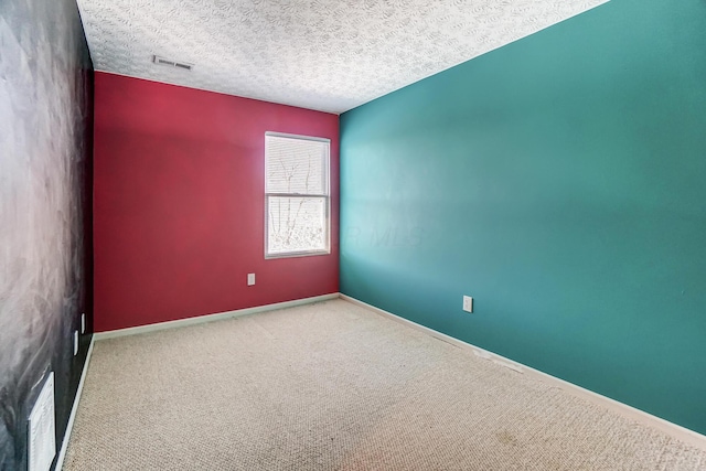 carpeted empty room with a textured ceiling