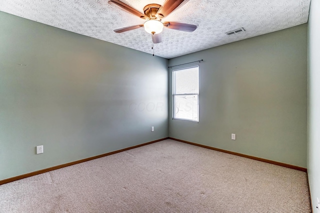 empty room featuring ceiling fan, a textured ceiling, and carpet