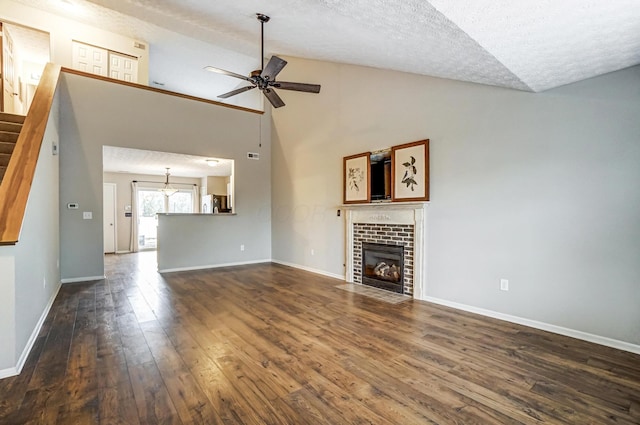 unfurnished living room with ceiling fan, dark wood-type flooring, a textured ceiling, and a fireplace