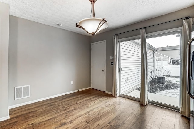 doorway with hardwood / wood-style flooring and a textured ceiling