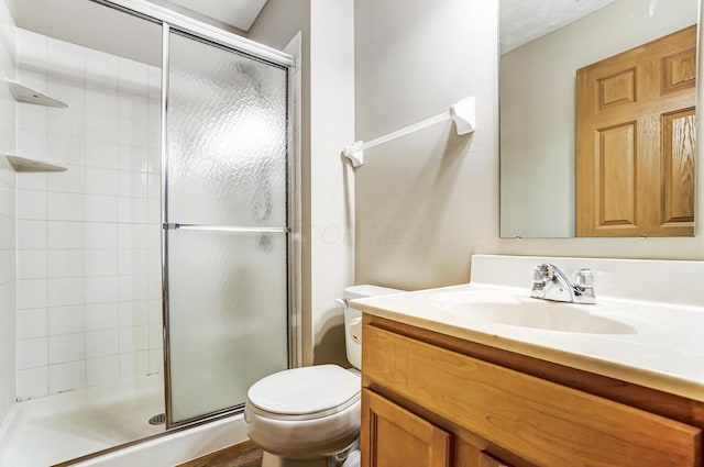 bathroom featuring vanity, toilet, and a shower with door