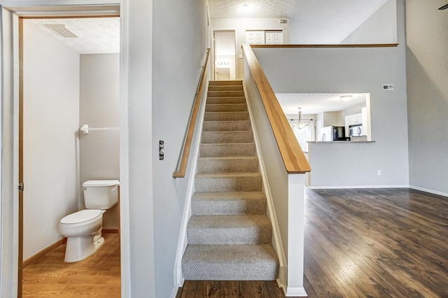 stairway featuring wood-type flooring and a textured ceiling