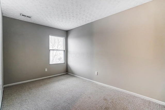 carpeted spare room with a textured ceiling