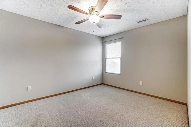 spare room featuring ceiling fan, carpet floors, and a textured ceiling