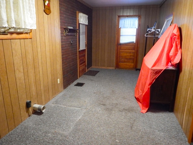 interior space featuring dark carpet and wood walls