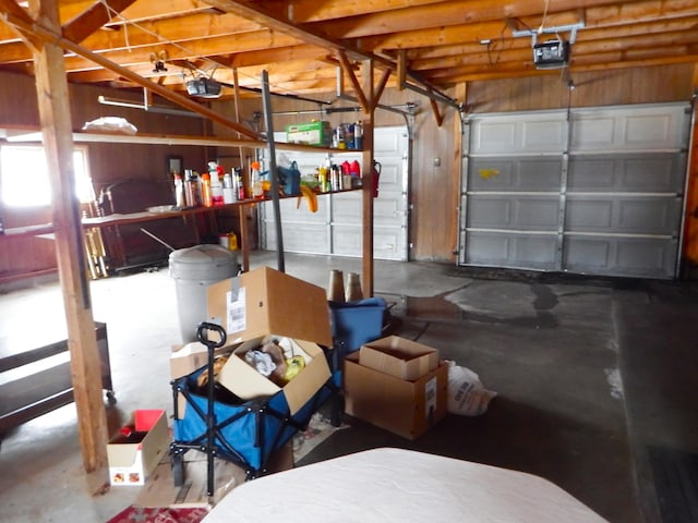 garage featuring a garage door opener and wood walls