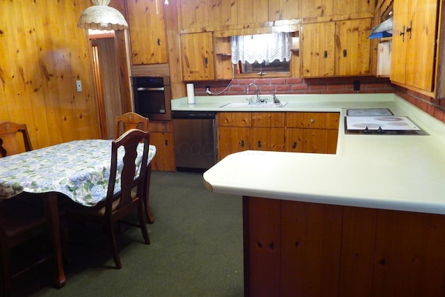 kitchen featuring appliances with stainless steel finishes, sink, wooden walls, and a kitchen bar