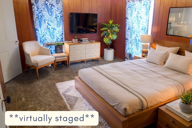 bedroom featuring dark colored carpet and wood walls