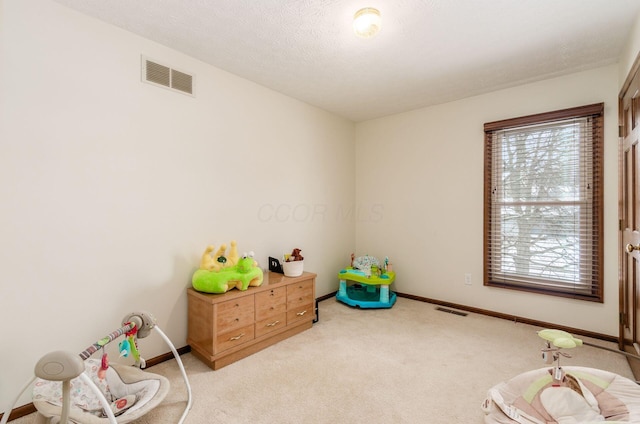 game room featuring light colored carpet and a textured ceiling