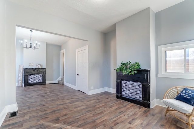 sitting room with dark wood-type flooring and a notable chandelier