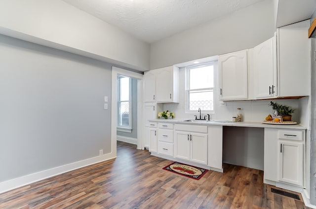 kitchen featuring white cabinets, decorative backsplash, dark hardwood / wood-style flooring, and plenty of natural light