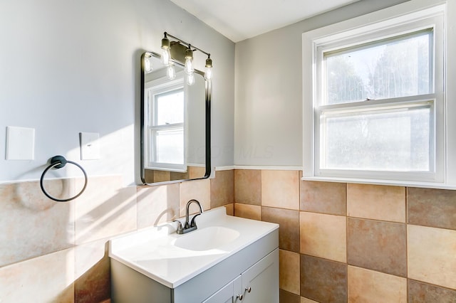 bathroom featuring vanity, plenty of natural light, and tile walls