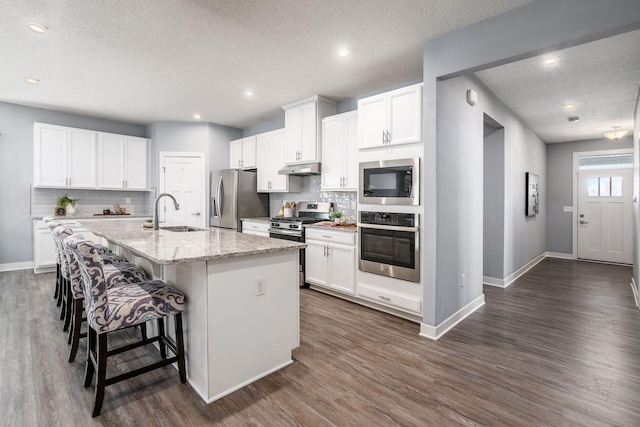 kitchen featuring white cabinetry, sink, an island with sink, and appliances with stainless steel finishes