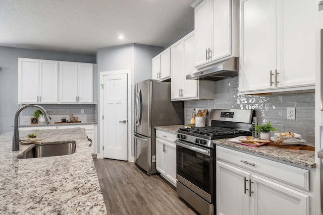 kitchen featuring light stone counters, sink, white cabinets, and appliances with stainless steel finishes