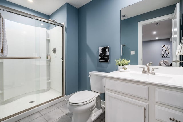 bathroom with vanity, toilet, a shower with shower door, and tile patterned flooring