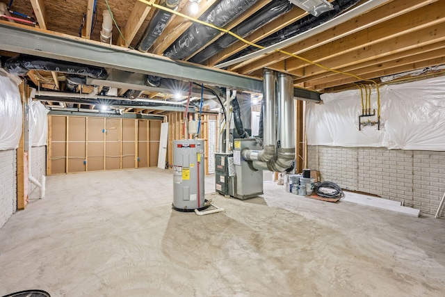 basement featuring brick wall, electric water heater, and heating unit